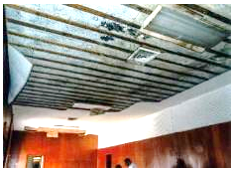 Before: view of second floor paneled walls and damaged ceiling prior to construction